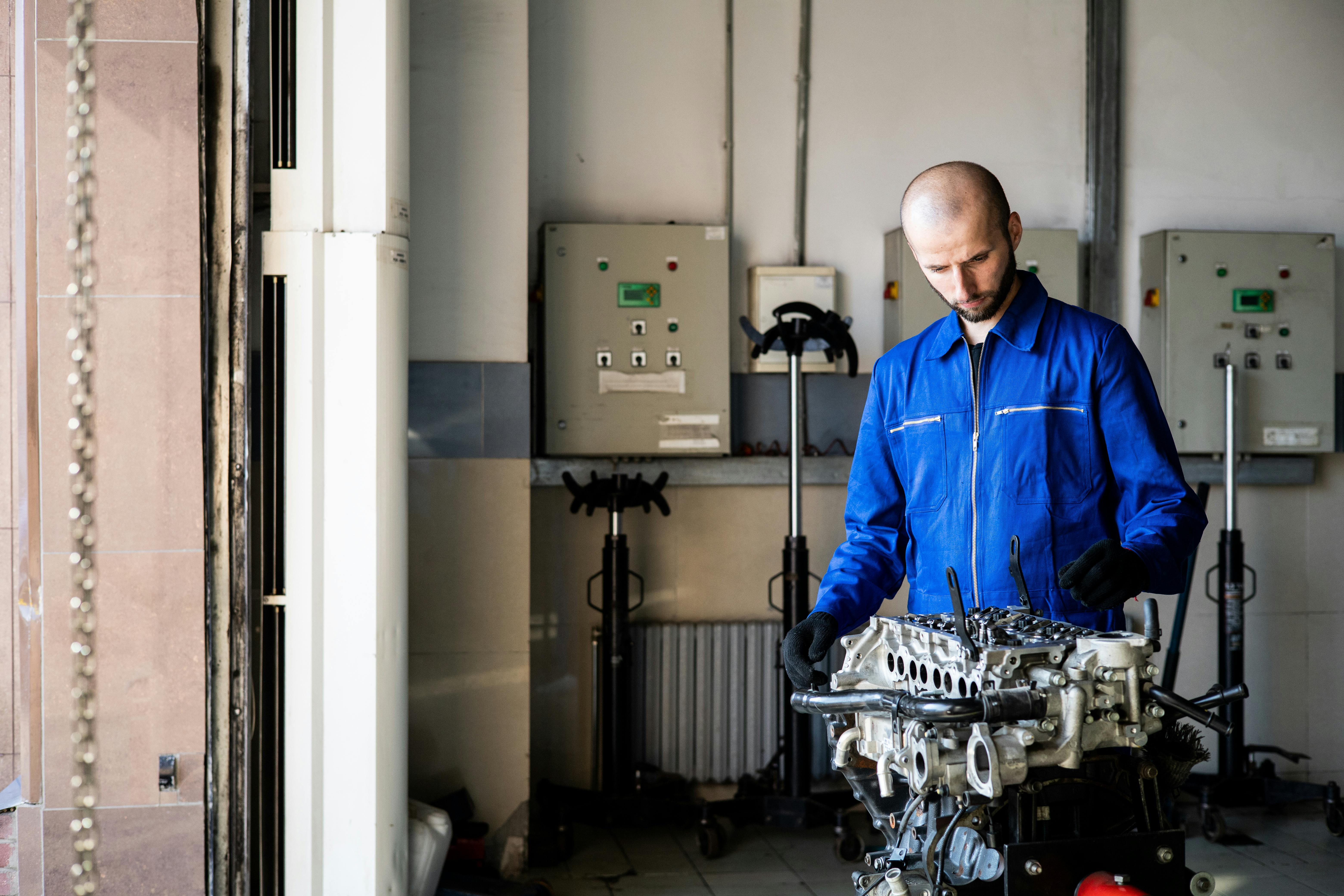 Auto technician inspecting a reconditioned engine on a workbench during servicing