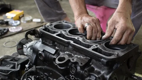 Close-up of hands installing engine components during engine fitting London