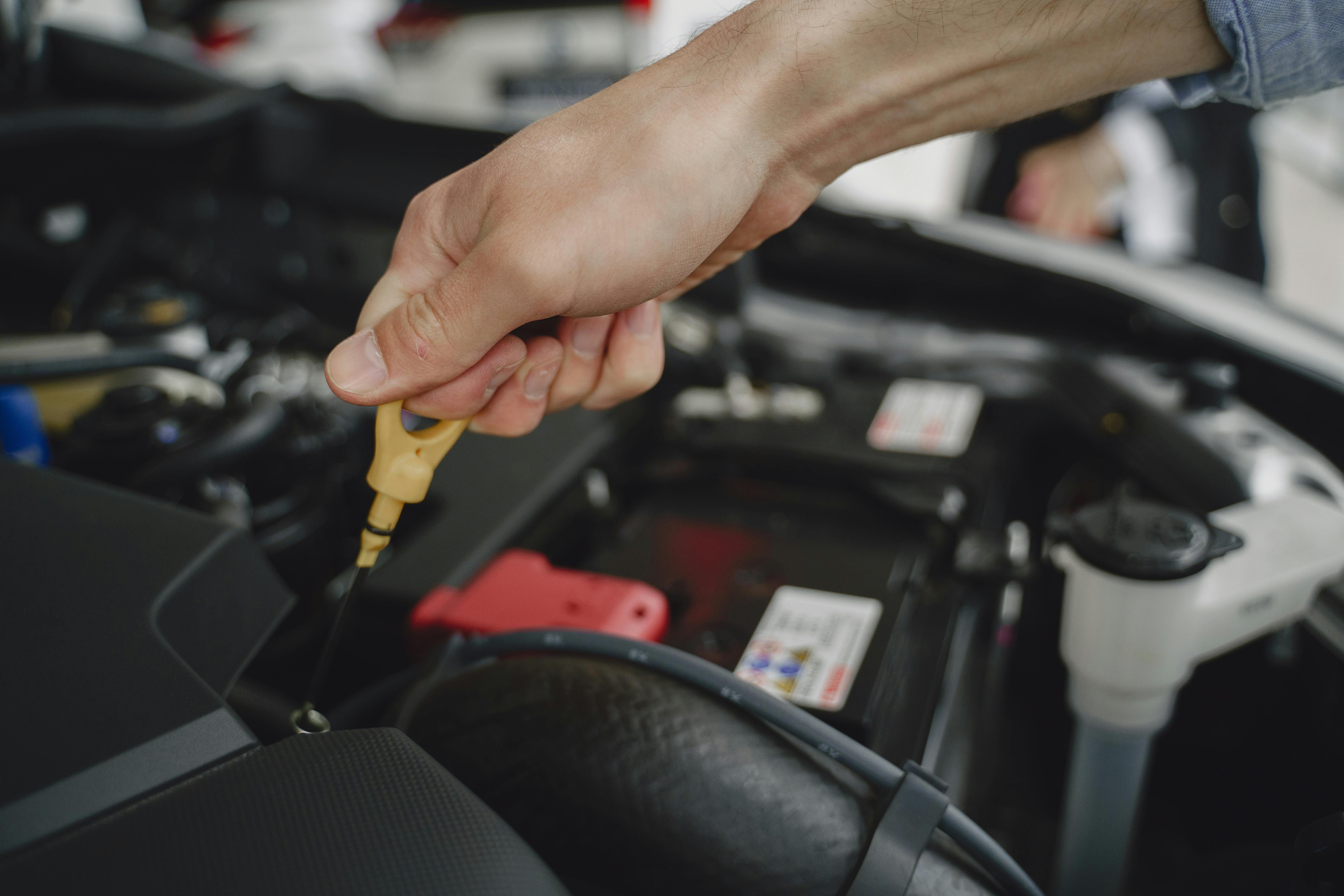 Vehicle Technician checking engine oil level for professional oil change service in Barking, London