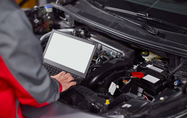 Technician using laptop for engine diagnosis at BNS MOTORS, Barking, London.