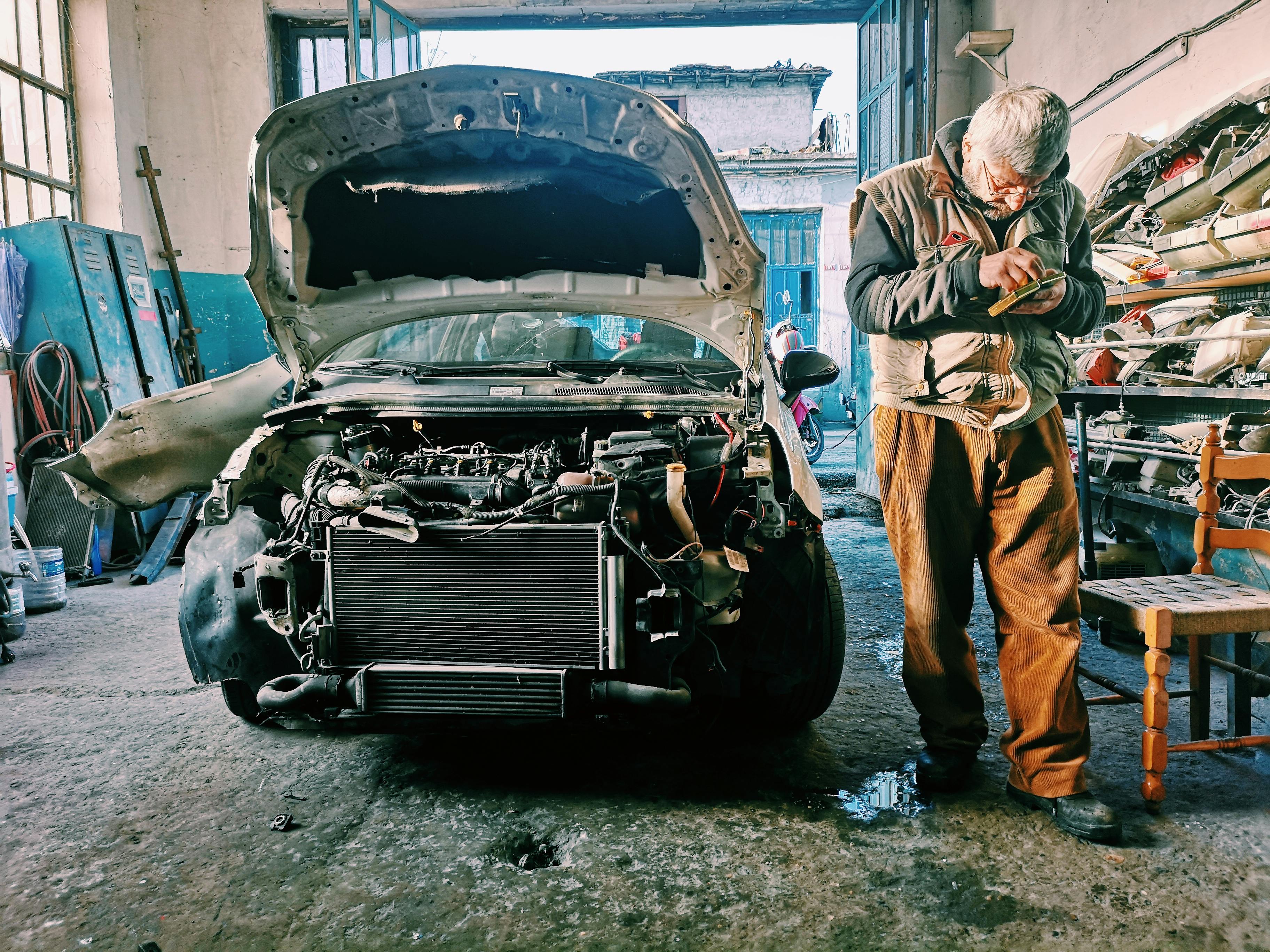 Technician performing clutch replacement Barking, London at BNS MOTORS under car lift.