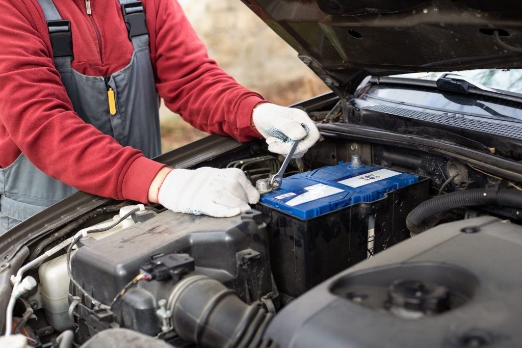 Auto mechanic holding wrench near car battery preparing for repair and maintenance work  at BNS MOTORS